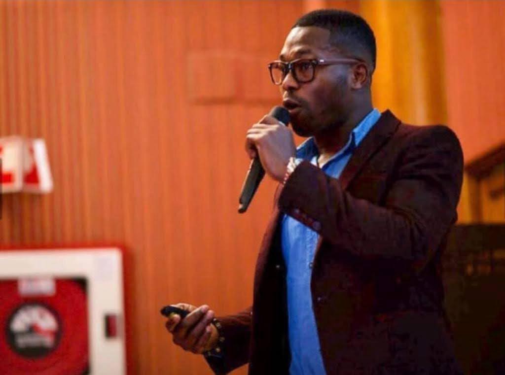 Man speaking into a microphone during a presentation.